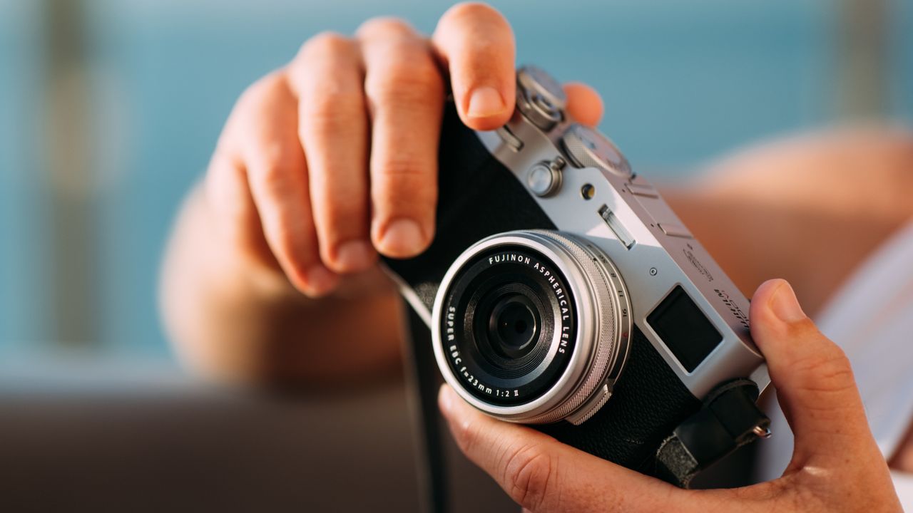 The Fujifilm X1000VI held against a blue sky background