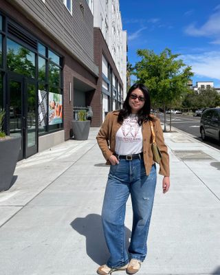 @marina_torres wears beige, retro-style trainers with jeans and a tan jacket in the streets in America