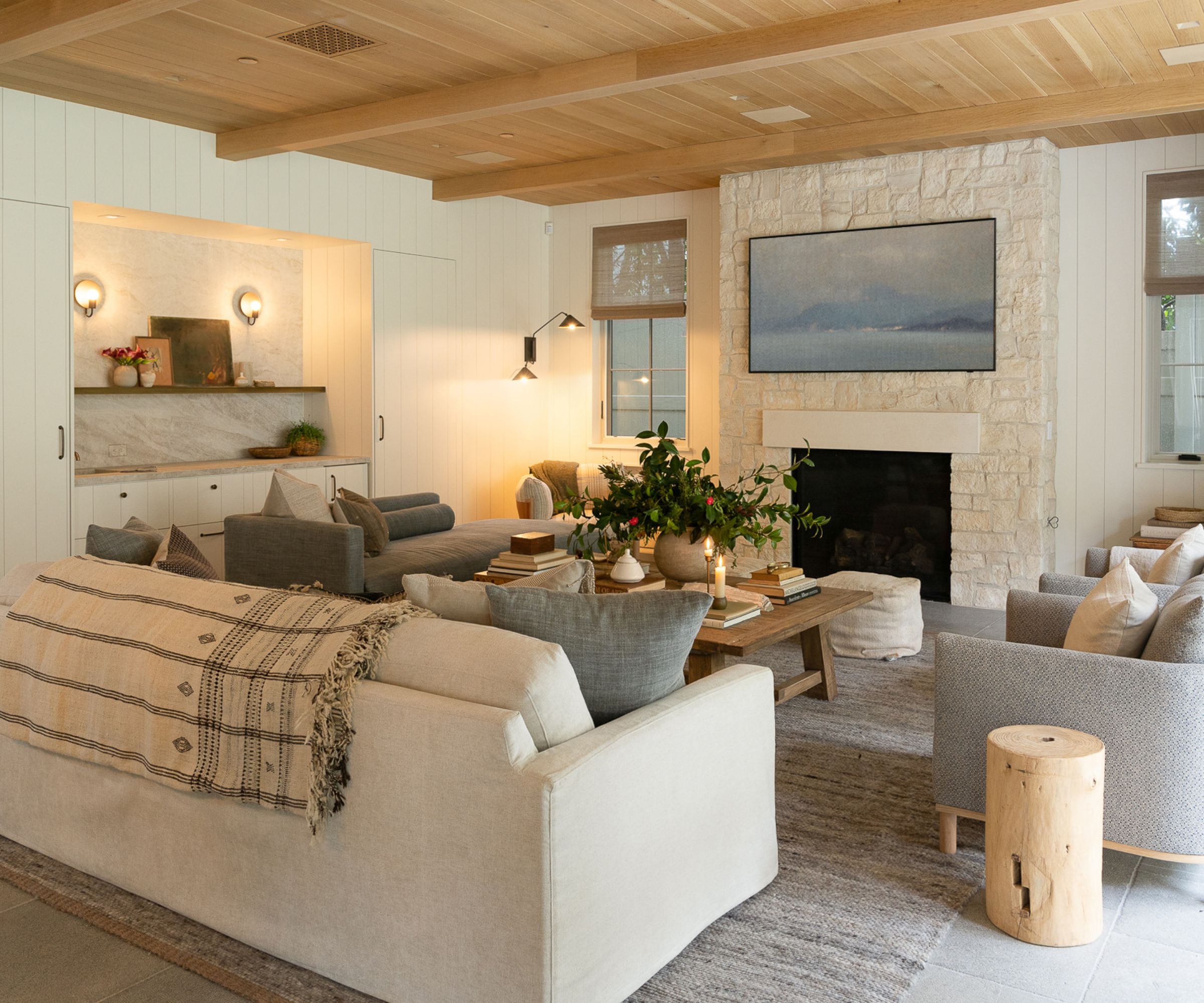 great room with white sofa, bar and fireplace