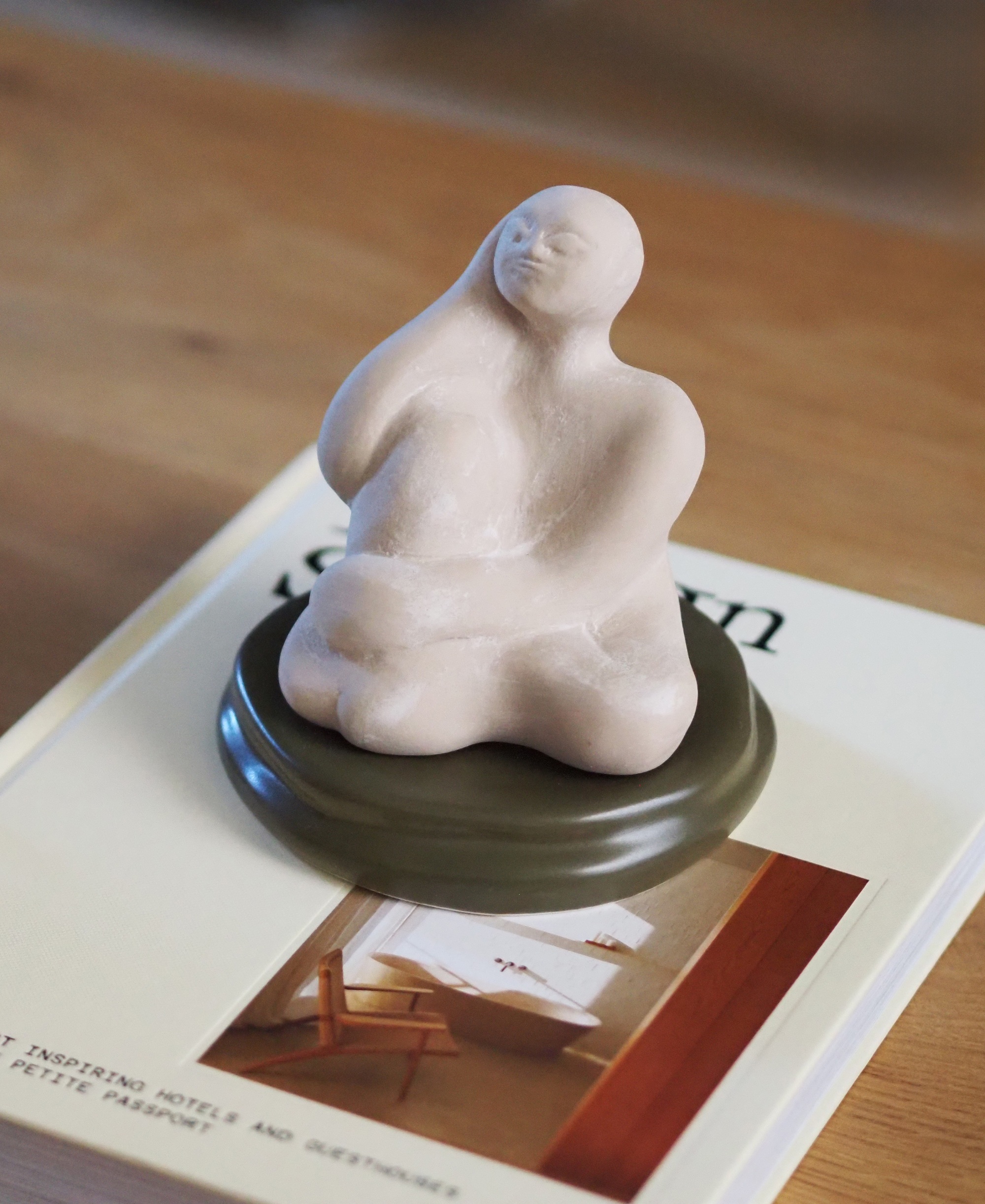 a scented statue on a coffee table on top of a book