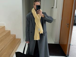 Anouk Yve in a yellow scarf and gray coat.