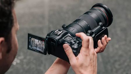 Rear view of a photographer holding the Canon RF 24-105mm f/2.8L IS USM Z lens attached to a Canon EOS R5