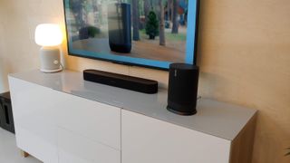 The Sonos Move pictured on a TV cabinet next to the Sonos Beam soundbar