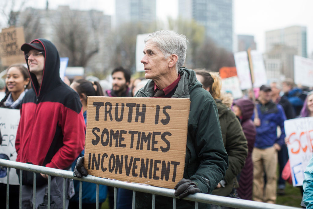 A man holds up his sign on the Boston Common during the March for Science in Boston, Massachusetts.