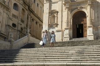 Meghann Fahy and Aubrey Plaza in 'The White Lotus' season 2 walking down stairs in noto