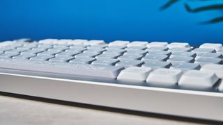 The NuPhy Nos75 mechanical keyboard on a stone surface with a blue background