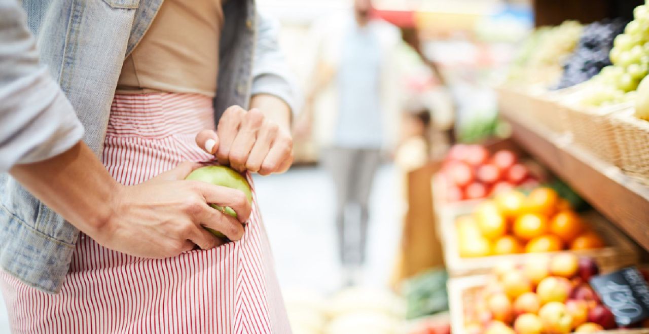 woman shoplifting an apple