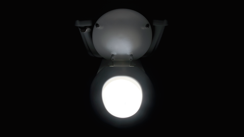 Toilet glowing and emitting light in the bathroom - stock photo