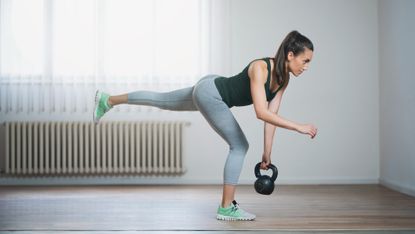 Woman doing a single-leg deadlift with a kettlebell