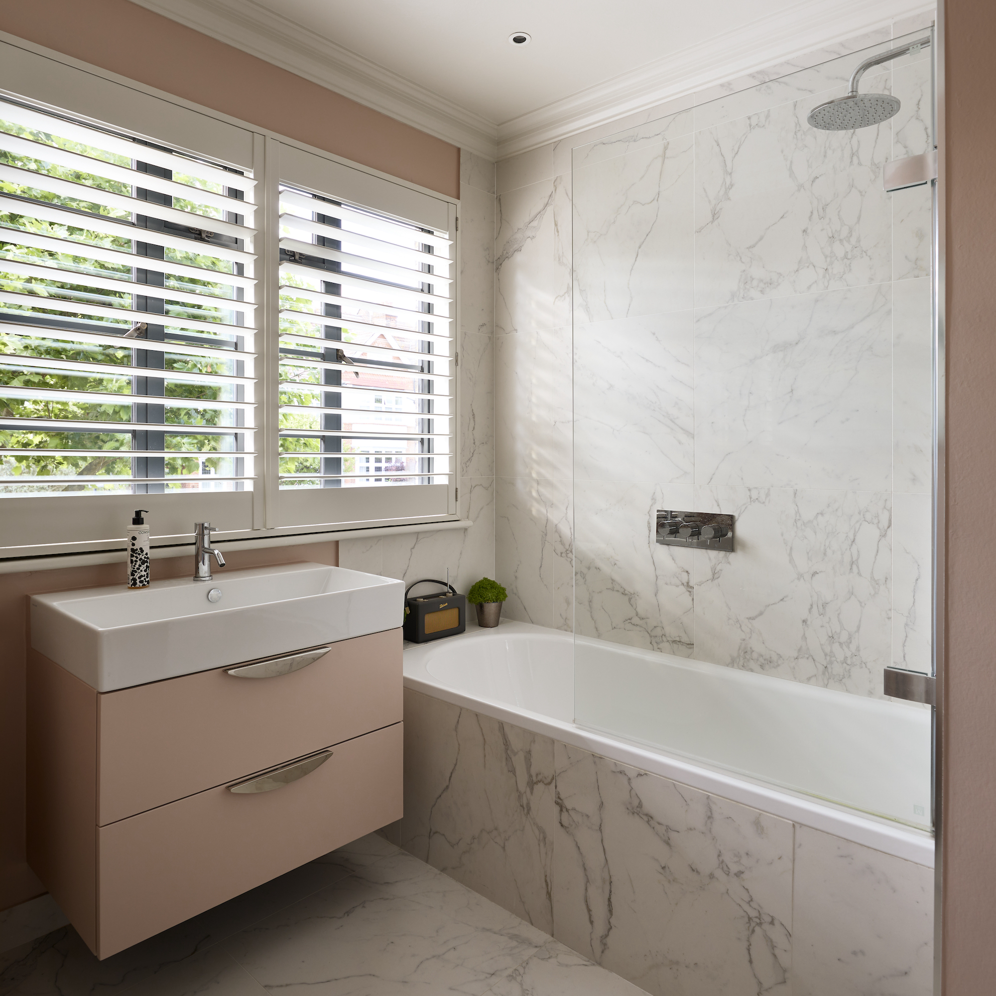 bathroom with marble floor and walls and pink floating vanity unit