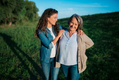 Mother and daughter hugging in a field