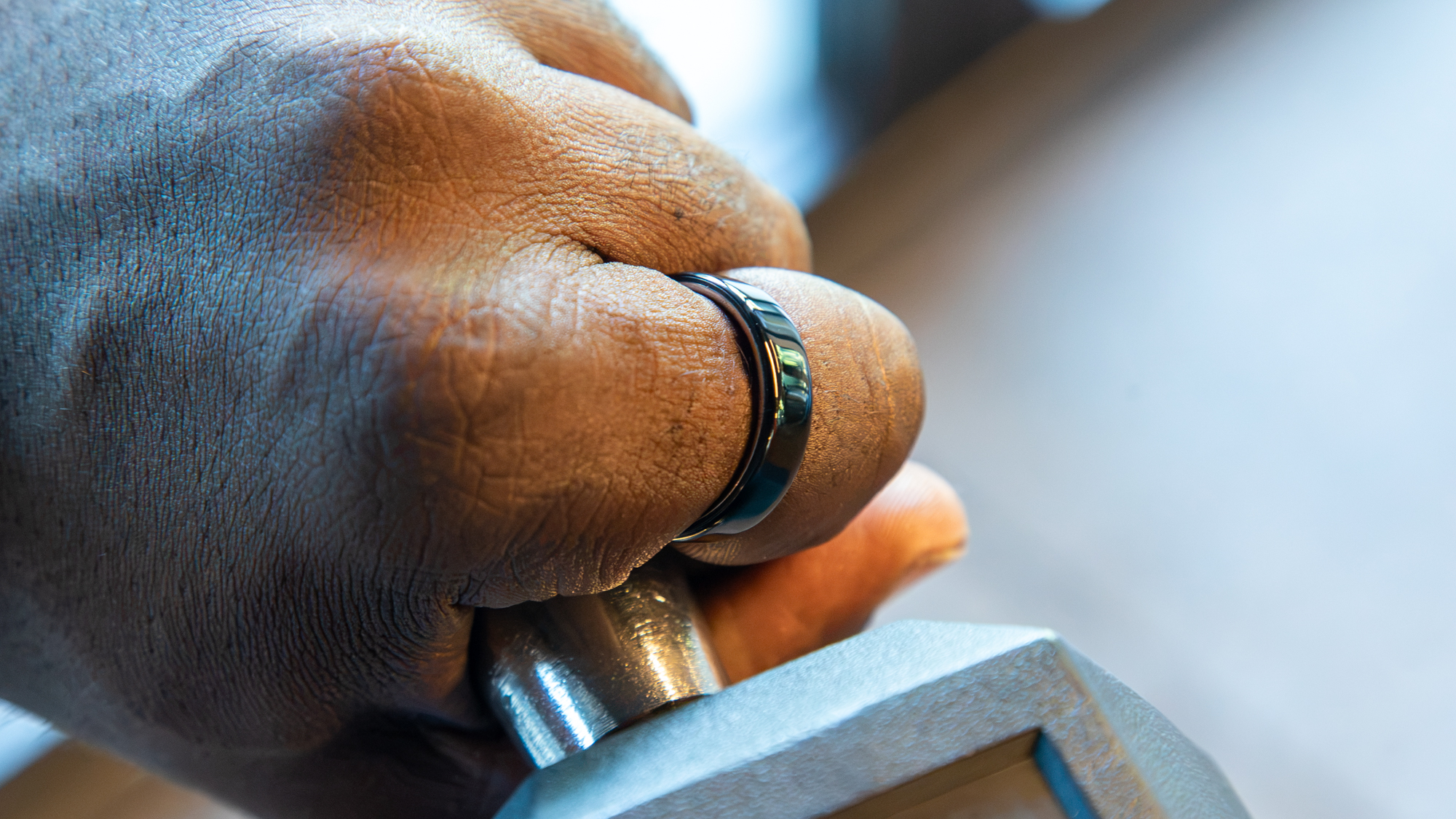 Wearing the Oura Ring 5 while holding a dumbbell