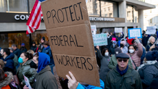 A demonstrator holds a "Protect Federal Workers" sign during a rally outside the US Consumer Financial Protection Bureau (CFPB) headquarters in Washington, DC, US, on Monday, Feb. 10, 2025. In another weekend takeover of a federal agency's operations, staffers from an efficiency initiative led by billionaire Elon Musk helped to effectively shut down the Consumer Financial Protection Bureau, as they gained access to an array of the bureau's protected information. Photographer: Stefani Reynolds/Bloomberg via Getty Images