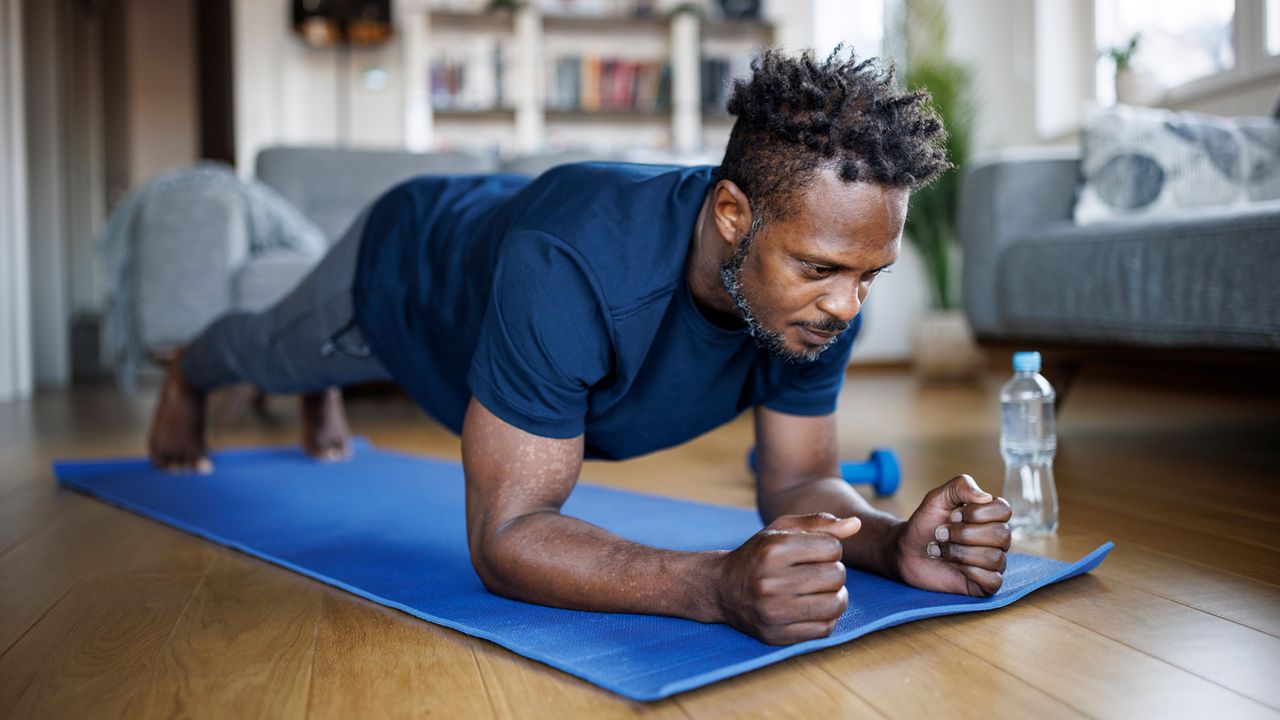 Man performs a plank doing a home workout