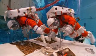 NASA astronauts Stan Love and Steve Bowen test tools and methods for exploring an asteroid in an underwater 'spacewalk' in this still from a NASA video released May 9, 2014.