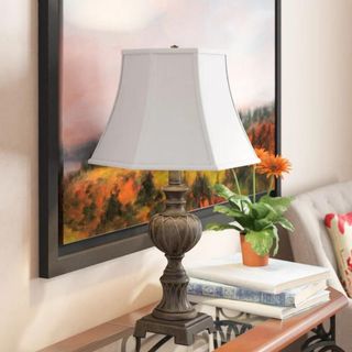 A table lamp from Wayfair with a white shade and metallic base
