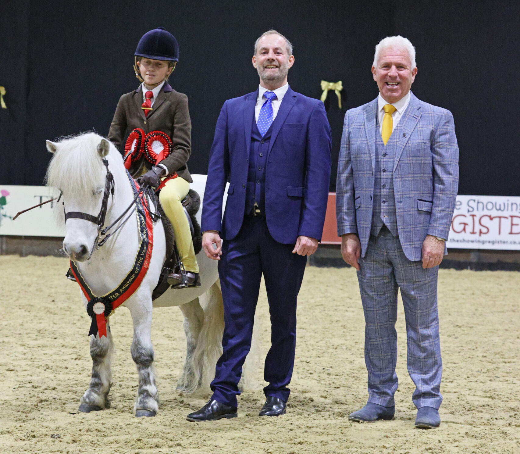 Briar Snowstorm Tillie Goulding stand for a photo with judges Mathew Lawrence and Anthony Perkins having won the M&amp;amp;M small breeds division at the 2025 TSR Amateur of the Year Championship show