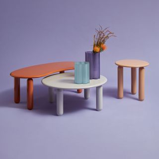 Three coffee tables on purple background