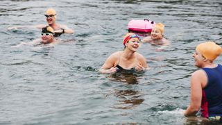 A group of open water swimmers in a lake