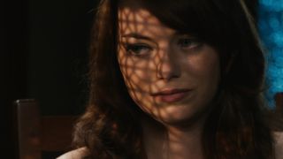 Emma Stone sitting in a confessional box in Easy A.