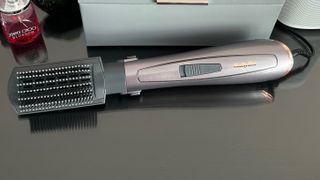 The BaByliss Air Style 1000 with the paddle brush attached on a glass countertop