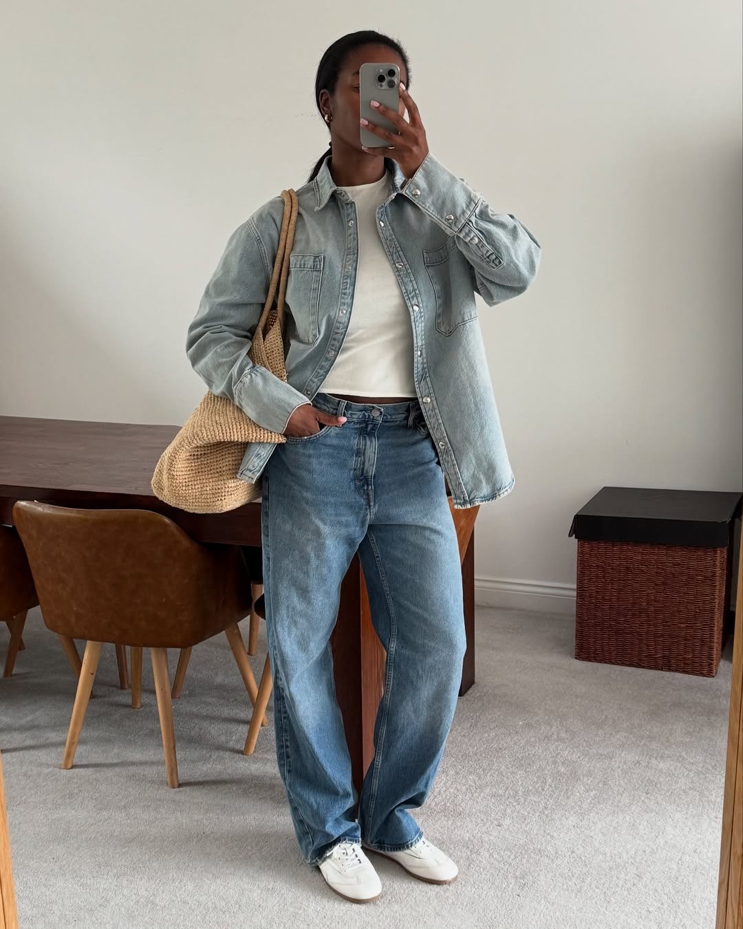 @nlmarilyn wearing jeans, white tee, jean button-down, and a straw woven tote