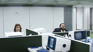 Deux employés de Lumon Industries lèvent les yeux de leur bureau dans la saison 1 de Severance.