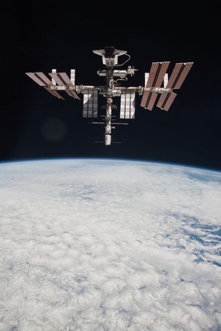 The space shuttle Endeavour is shown docked at the International Space Station in this first-ever view of the two spacecraft together as seen by astronauts on a nearby Russian Soyuz spacecraft. Expedition 27 crew member Paolo Nespoli from the Soyuz TMA-20