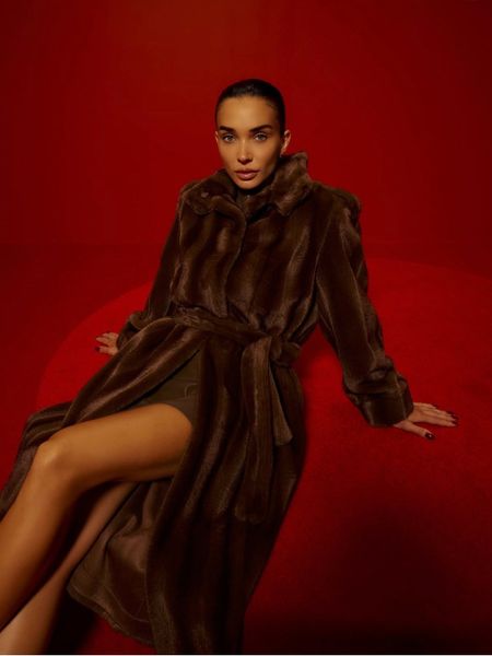 Woman in furry coat on red seat