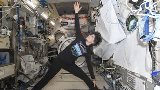 Expedition 67 astronaut Samantha Cristoforetti, of the European Space Agency, holds a yoga pose on the International Space Station.