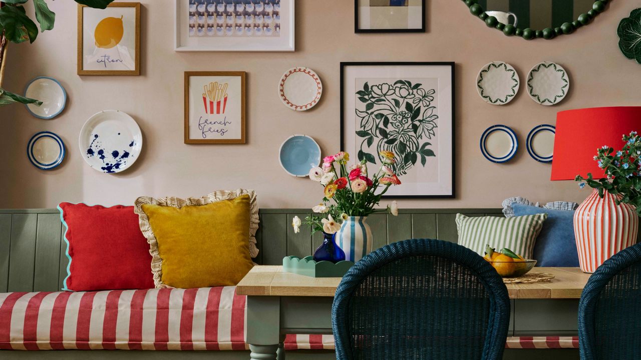 A dining table with banquet seating and a gallery wall above