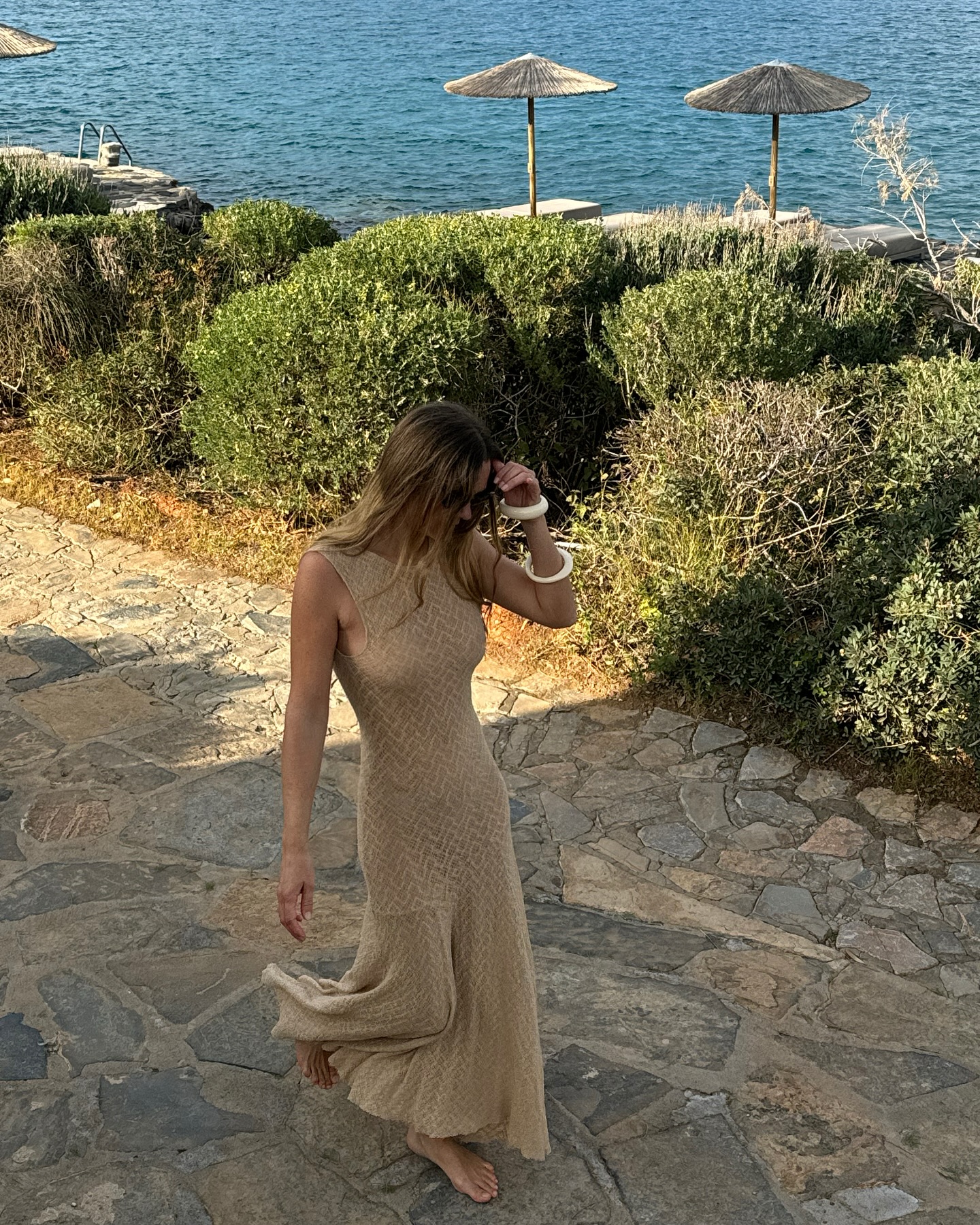 Anne Laure Mais wears a camel crochet dress on the beach