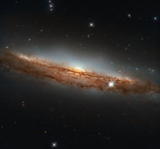 This photo from the Hubble Space Telescope shows the spiral galaxy NGC 3717, a dusty swirl of stars about 60 million light-years away.