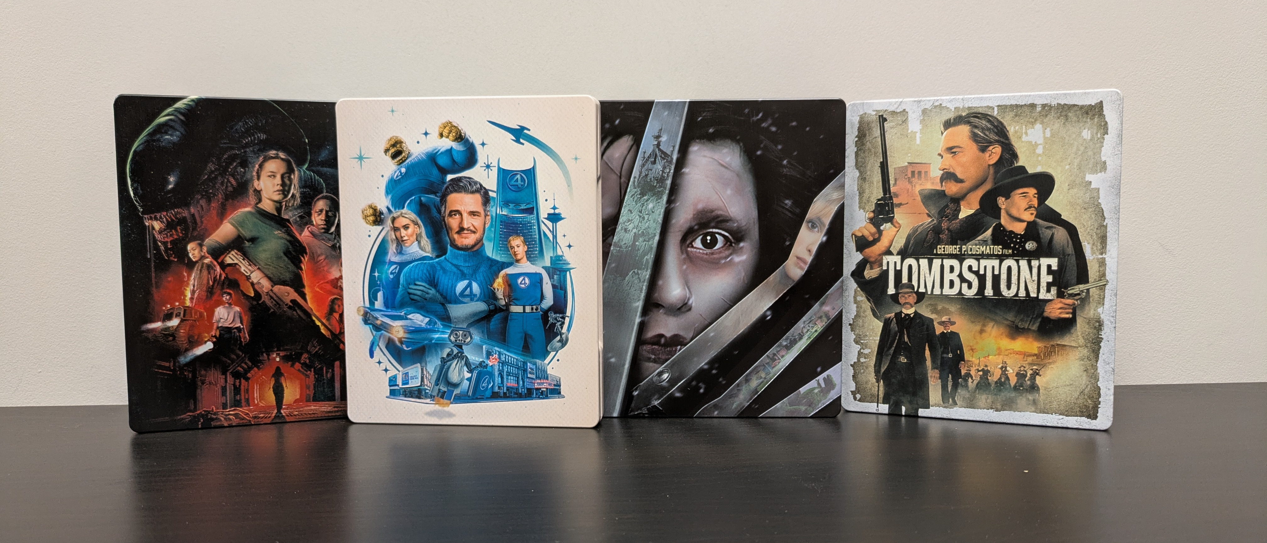 4K Blu-ray collection hero image with steelbook cases of tombstone, the fantastic four first steps, edward scissorhands and alien romulus 