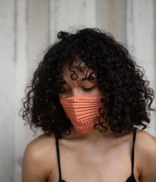 Woman wearing peach facemask by Petit Pli