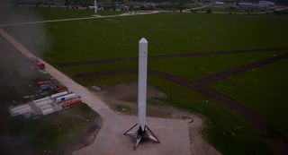 SpaceX's Falcon 9 Reusable rocket prototype stands atop a launch pad at the firm's McGregor, Texas test site after a successful debut flight to an altitude of 820 feet (250 meters). SpaceX's smaller Grasshopper reusable rocket prototype is visible at upp