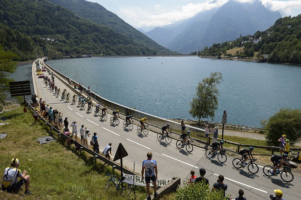 The peloton riding by beautiful scenery during stage 18