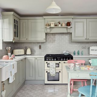 A country style kitchen with French grey cupboards, metro wall tiles and mosaic floor tiles