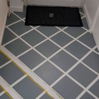 hallway with grey tile painted flooring and mat
