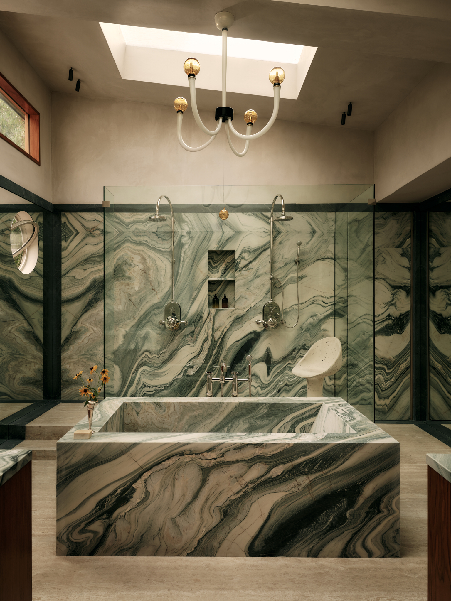 marble bathroom bathtub and walls, with a skylight above