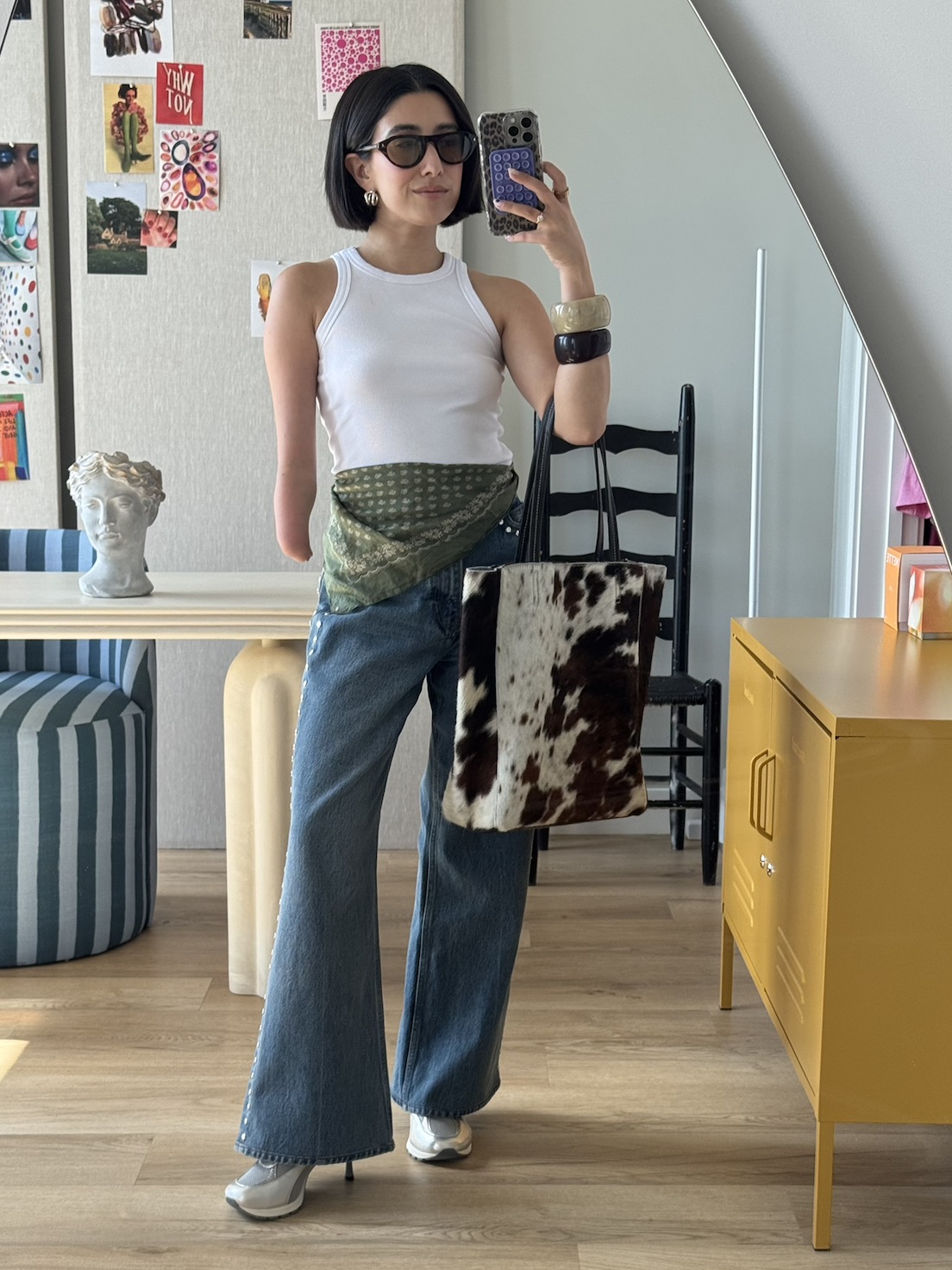 April Lockhart wearing a white tank top and flare jeans