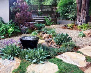 Large flagstones and gravel and dry plants create a xeriscaping landscape