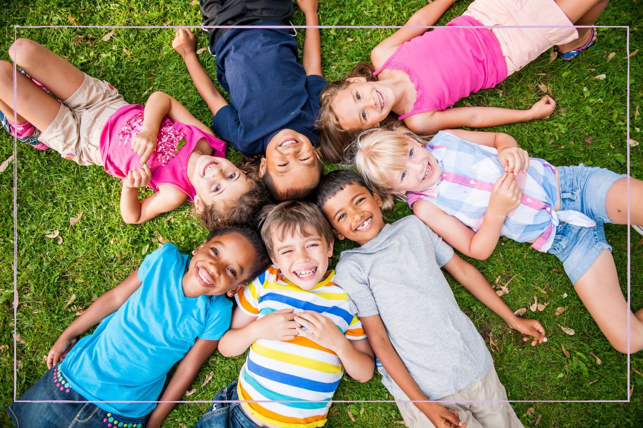 How to raise happy kids as illustrated by a group of smiling children laying in a circle