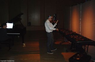 Soloist Stephane Tran Ngoc tests the tonal qualities of a violin at Auditorium Coeur de Ville in Vincennes, near Paris.