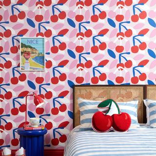 A bedroom decorated with red, white, pink and red cherry wallpaper