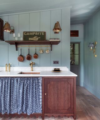 light blue kitchen with wooden units and rustic decor