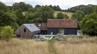 black barn with timber extension to rear