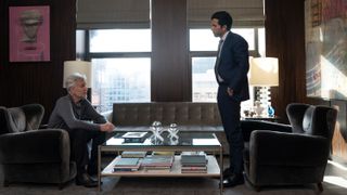 Jake and Bill standing in a plush office having what looks like a deep conversation.