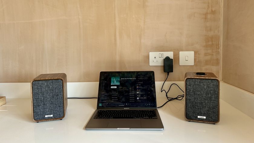 Ruark MR1 Mk3 powered speakers either side of a laptop, on a white surface