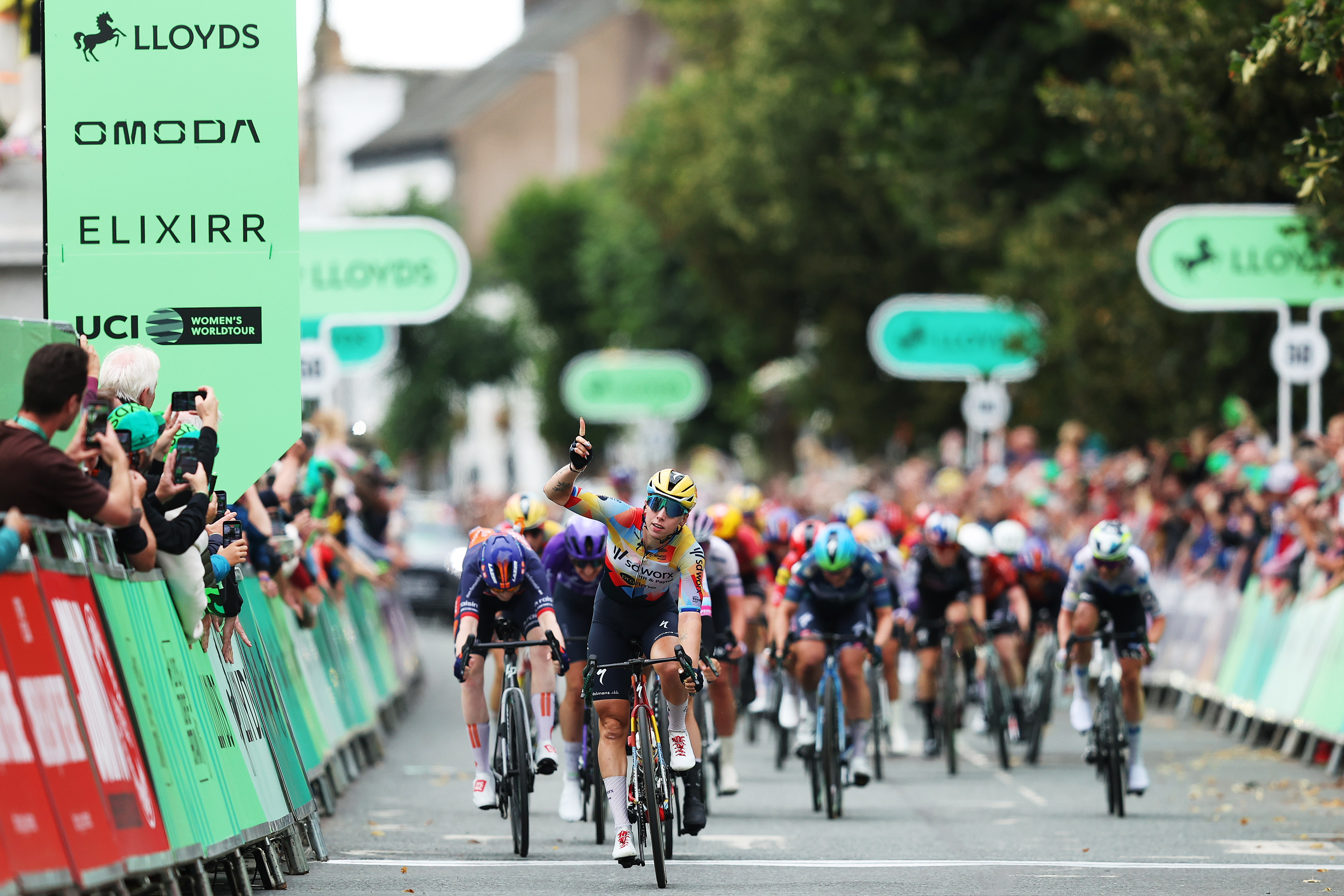 Lorena Wiebes points to the sky on her bike having won stage one of the Tour of Britain Women